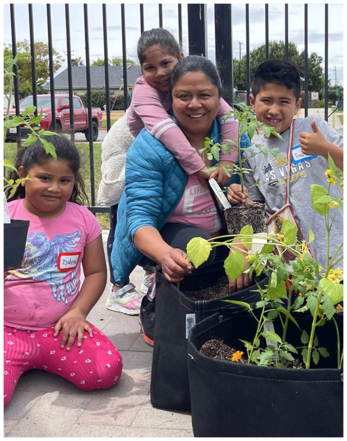 The Editor’s Desk A smiling woman and three children plant vegetables together in portable grow bags during a Monterey Bay Master Gardeners workshop.