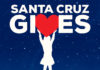 The Giving Season Santa Cruz Gives logo featuring a silhouette holding up a red heart against a starry blue background.