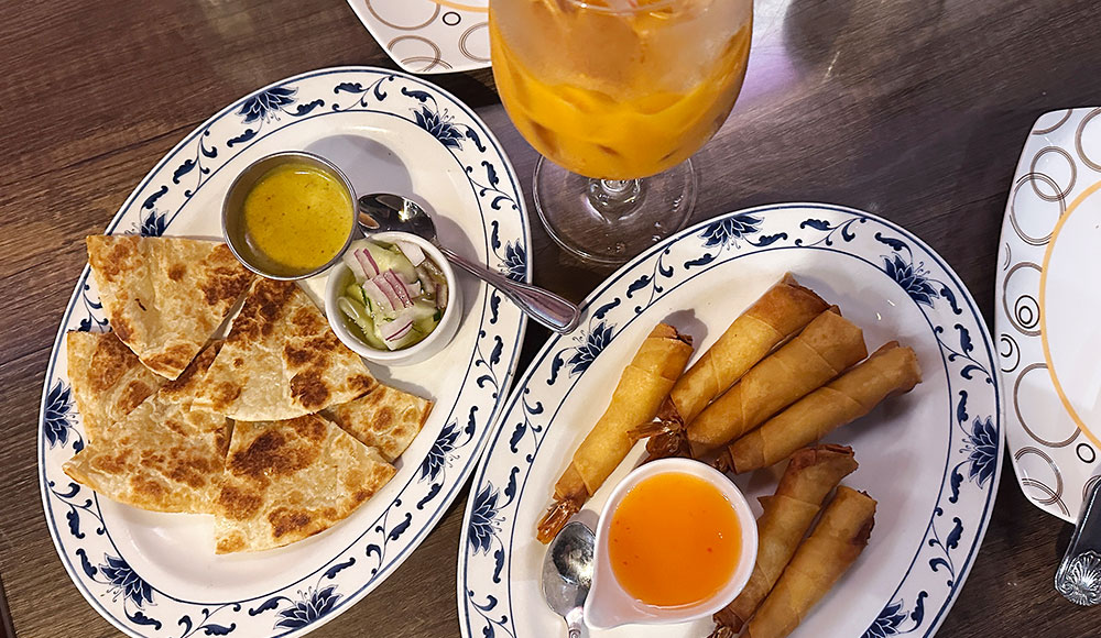 Shared plates at Coconut Thai featuring roti with dipping sauces and crispy coconut shrimp.