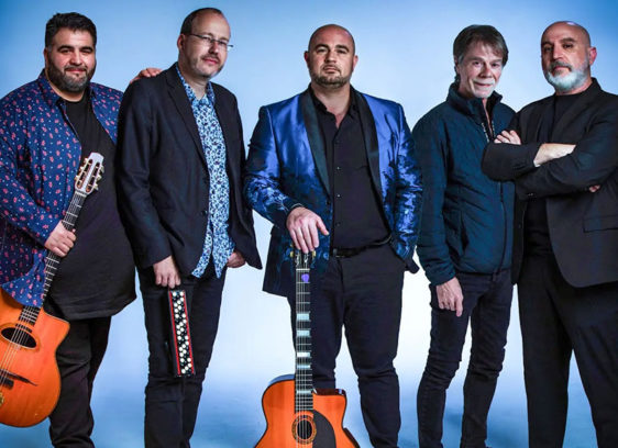 Things to do in Santa Cruz The Django Festival Allstars stand together holding guitars, posing against a light blue studio background.