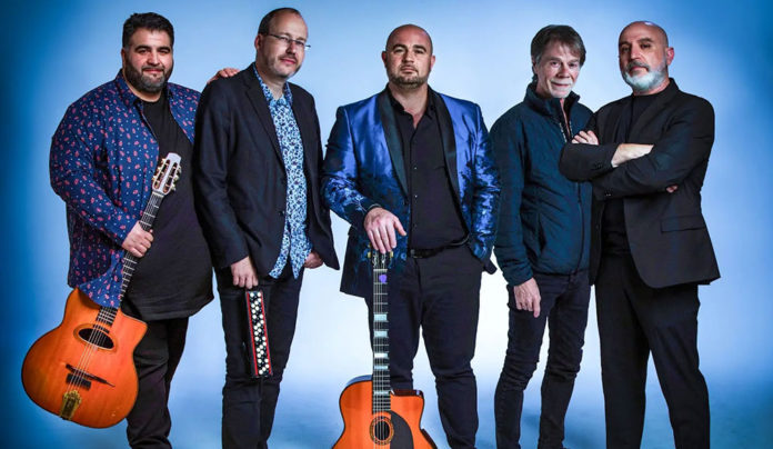 Things to do in Santa Cruz The Django Festival Allstars stand together holding guitars, posing against a light blue studio background.