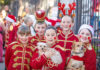 Solstice Groove Children dressed in festive toy-soldier costumes pose with two small dogs during a Santa Cruz holiday celebration.