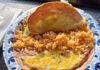 Taco Tradition Shredded beef crispy taco served with Mexican rice and refried beans topped with melted cheese at Las Palmas Taco Bar.