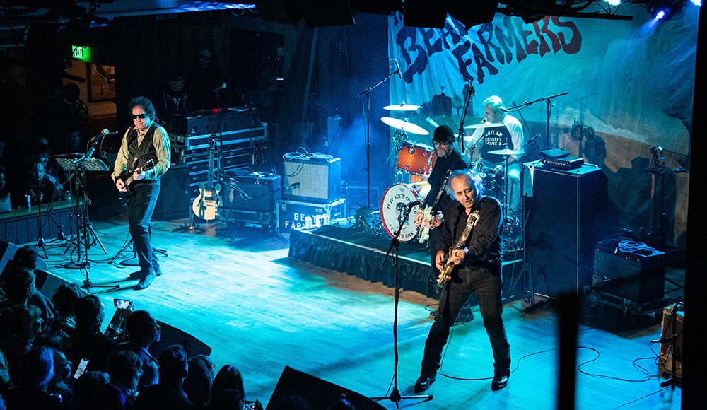 The Beat Farmers performing live on stage with guitars and drums before a crowd at Moe’s Alley.