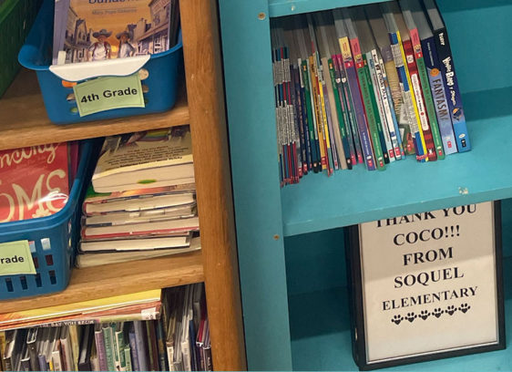 Path to Literacy Bookshelves at Soquel Elementary filled with children’s books, with a small sign reading “Thank You Coco!!! From Soquel Elementary.”