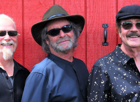 Brotherhood of Snail Original members of Santa Cruz rock band Snail standing together against a red wall