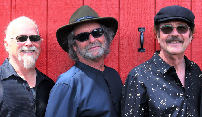 Brotherhood of Snail Original members of Santa Cruz rock band Snail standing together against a red wall