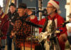 Things to do in Santa Cruz A holiday jug band performs live onstage, with musicians singing into microphones and playing acoustic instruments.