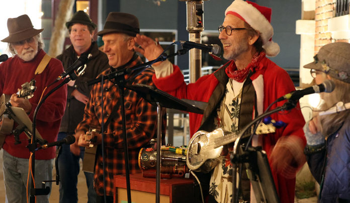 Things to do in Santa Cruz A holiday jug band performs live onstage, with musicians singing into microphones and playing acoustic instruments.