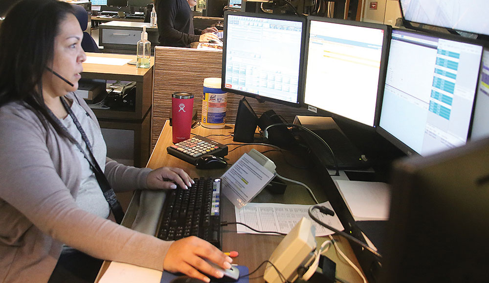 Woman sitting in front of multiple computer screens