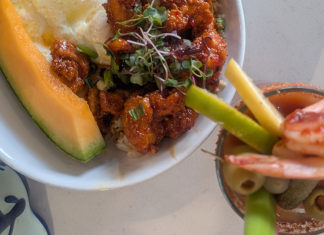 Franchise Player Korean chicken fried rice with fried egg and melon, alongside a loaded Baltimore Bloody Mary with prawns and bacon at The Breakfast Club.