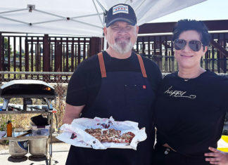Sunflower Soul J.R. Chapman and Viviana of Girasol Pizza hold a Chicago-style thin-crust pizza at a pop-up food setup.
