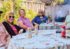 Be Prepared Members of Village Santa Cruz County gather around a table outdoors, enjoying conversation and refreshments together.