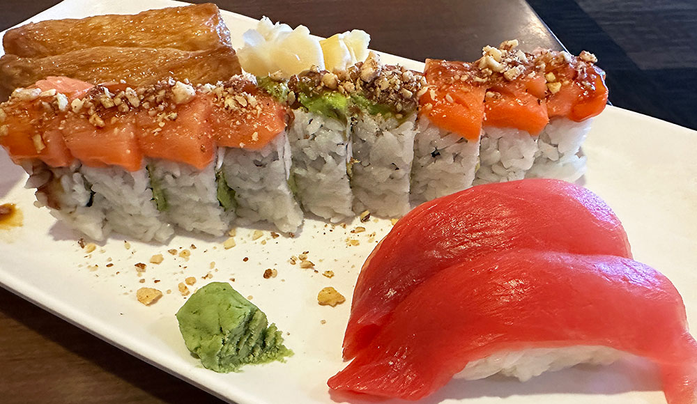 A plate of sushi at Imura in Watsonville featuring inari, a specialty roll topped with salmon and maguro nigiri.