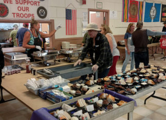 The Wednesday Lifeline Volunteers prepare and serve meals inside the Santa Cruz Veterans Memorial Building during the weekly Veterans Meal and Pantry Program.
