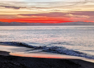 Ending With Intention Waves roll onto a Santa Cruz beach at sunset beneath a streaked winter sky.
