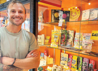 Santa Cruz County Moves Closer to Cannabis Consumption Lounges Man standing in front of a display of cannabis products