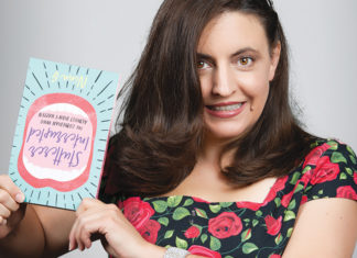 Camera. Lights. Ssss Comedian Nina G holds a copy of her memoir while posing for a portrait.