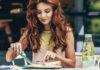 Dining Solo? A woman sits at a table cutting food on a plate during a solo meal.