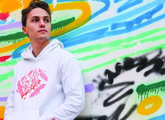 Things to do in Santa Cruz Italian guitar prodigy Matteo Mancuso poses in front of a colorful mural