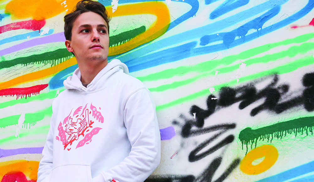 Italian guitar prodigy Matteo Mancuso poses in front of a colorful mural