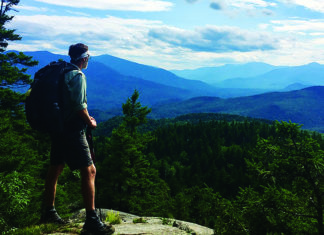 The Editor’s Desk Hiker looks out over forested mountains during a long-distance trek