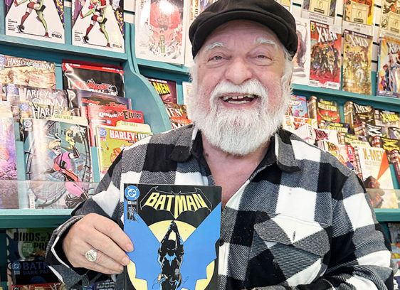 The Editor’s Desk Joe Ferrara holding a Batman comic inside Atlantis Fantasyworld in Santa Cruz