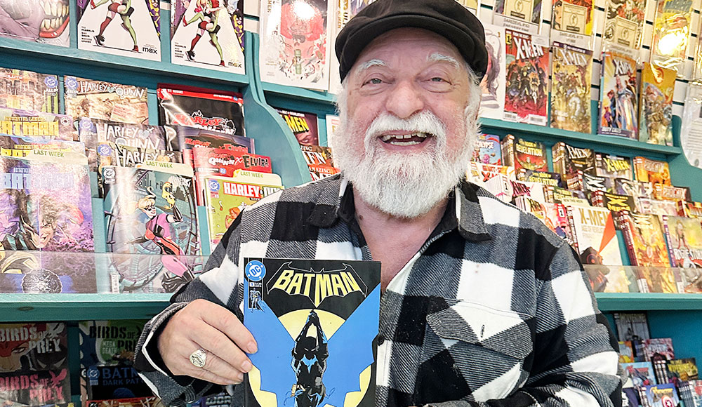 Joe Ferrara holding a Batman comic inside Atlantis Fantasyworld in Santa Cruz