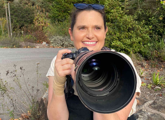 Local Photographer Captures International Attention Photographer Rebecca E. Hall holding a camera outdoors in Santa Cruz County