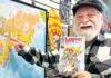 50 Years of Atlantis Fantasyworld Joe Ferrara holding a Vampires Everywhere comic beside a world map inside Atlantis Fantasyworld