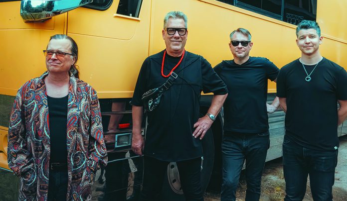 Things to do in Santa Cruz Violent Femmes pose in front of a yellow tour bus ahead of their Santa Cruz Civic Auditorium show.
