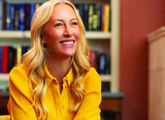 Brite Idea Julia Hartz smiles during an interview, seated indoors with bookshelves behind her