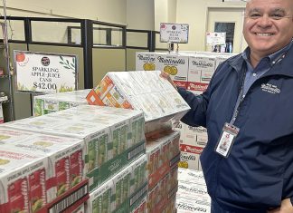 Watsonville Airport prepares for Super Bowl arrivals Man stands beside stacked cases of Martinelli’s sparkling beverages at Watsonville Municipal Airport