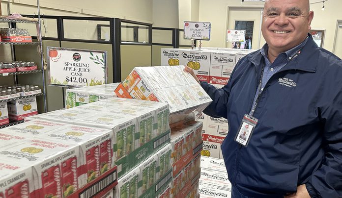 Watsonville Airport prepares for Super Bowl arrivals Man stands beside stacked cases of Martinelliโs sparkling beverages at Watsonville Municipal Airport