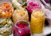 Good Gut Jars of fermented vegetables including sauerkraut, pickles, and colorful cabbage on a rustic table