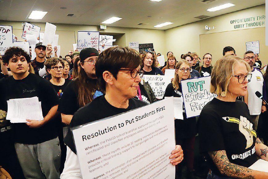 Teachers and staff hold a petition and protest PVUSD layoffs during a packed Pajaro Valley Unified School District board meeting in Watsonville.