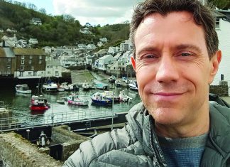 100 Years of Suspense Artist Rich Karat Hitchcock stands above the harbor in Polperro, Cornwall, England.
