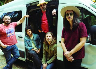 Making the Mountains Sing The Coffis Brothers standing outside their tour van in a wooded setting