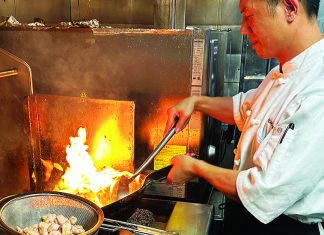 Fun Fusion Chef Hongmin Mo cooking with flames in Fusion Fare kitchen