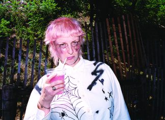 Things to do in Santa Cruz Liz Cooper holding a drink with pink hair and dramatic makeup outdoors