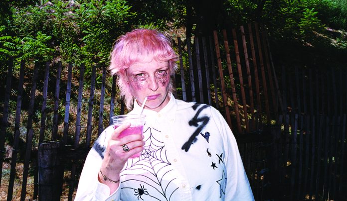 Things to do in Santa Cruz Liz Cooper holding a drink with pink hair and dramatic makeup outdoors