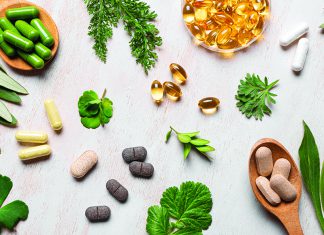 Herbal Quackery? Various herbal supplements and capsules with green leaves on table