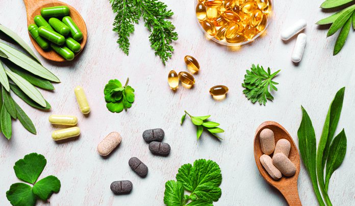 Herbal Quackery? Various herbal supplements and capsules with green leaves on table