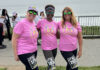 Hitting Their Stride Women runners in pink shirts at She Is Beautiful 5K Santa Cruz along West Cliff Drive