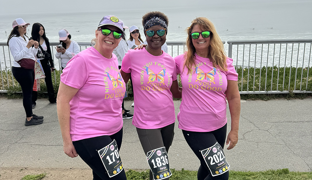 Women runners in pink shirts at She Is Beautiful 5K Santa Cruz along West Cliff Drive