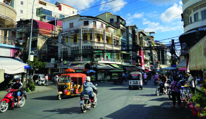 Home School Asia Busy street scene in Phnom Penh Cambodia with tuk tuks and motorbikes