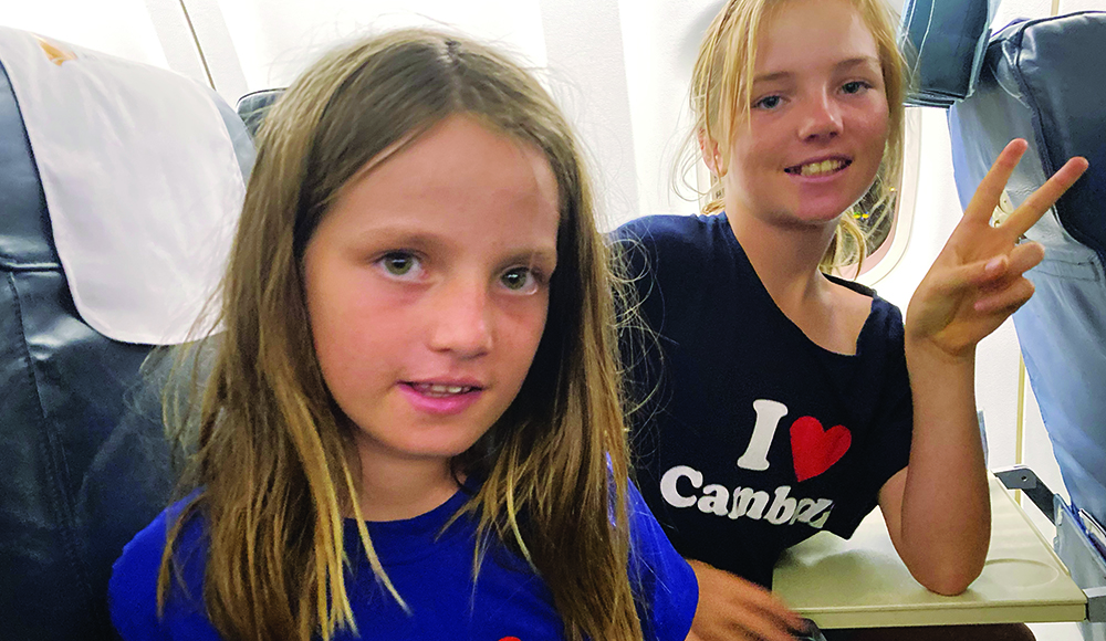 Children on airplane beginning family trip to Asia