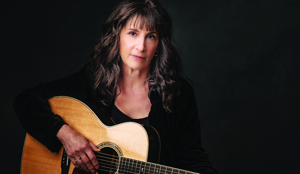 Singer-songwriter Karla Bonoff holding an acoustic guitar