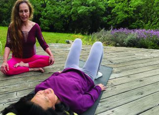 Shake, Breathe, or Rewire? woman practicing guided relaxation on yoga mat with instructor outdoors Santa Cruz