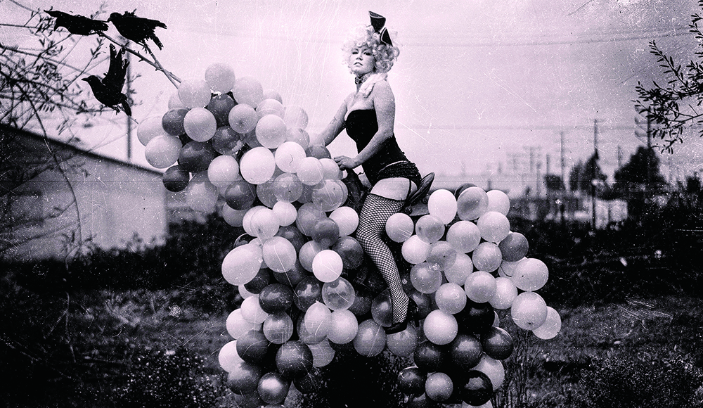 Performer posed on balloon horse sculpture by artist Michael Garlington
